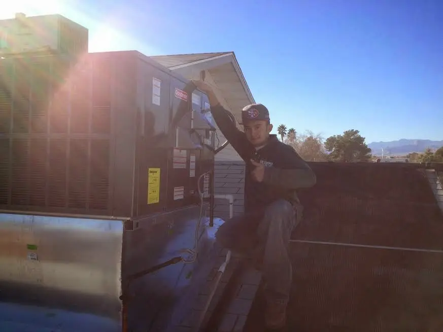 HVAC technician performing AC Tune-Up on a rooftop unit in Marlboro Village